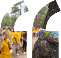 Photo of campers throwing up the fork with a colorful painted rock in the background with the message "Today is a great day" painted on it.